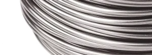 Close-up of shiny steel wire coils wound in parallel, forming concentric circles on a spool surface.